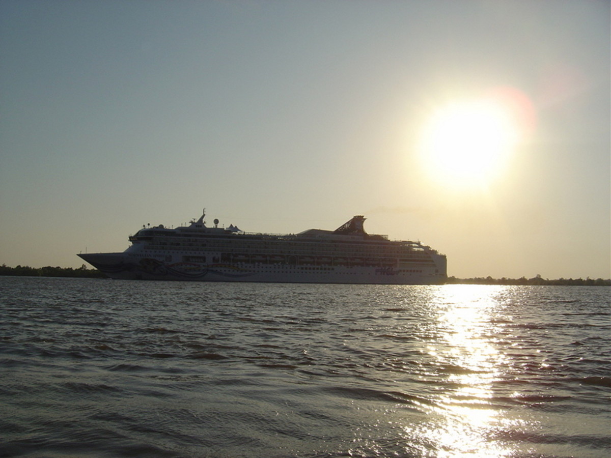 A large cruise ship carries passengers on the Mississippi River, heading toward the mouth of the big river, the Gulf of Mexico and points south.