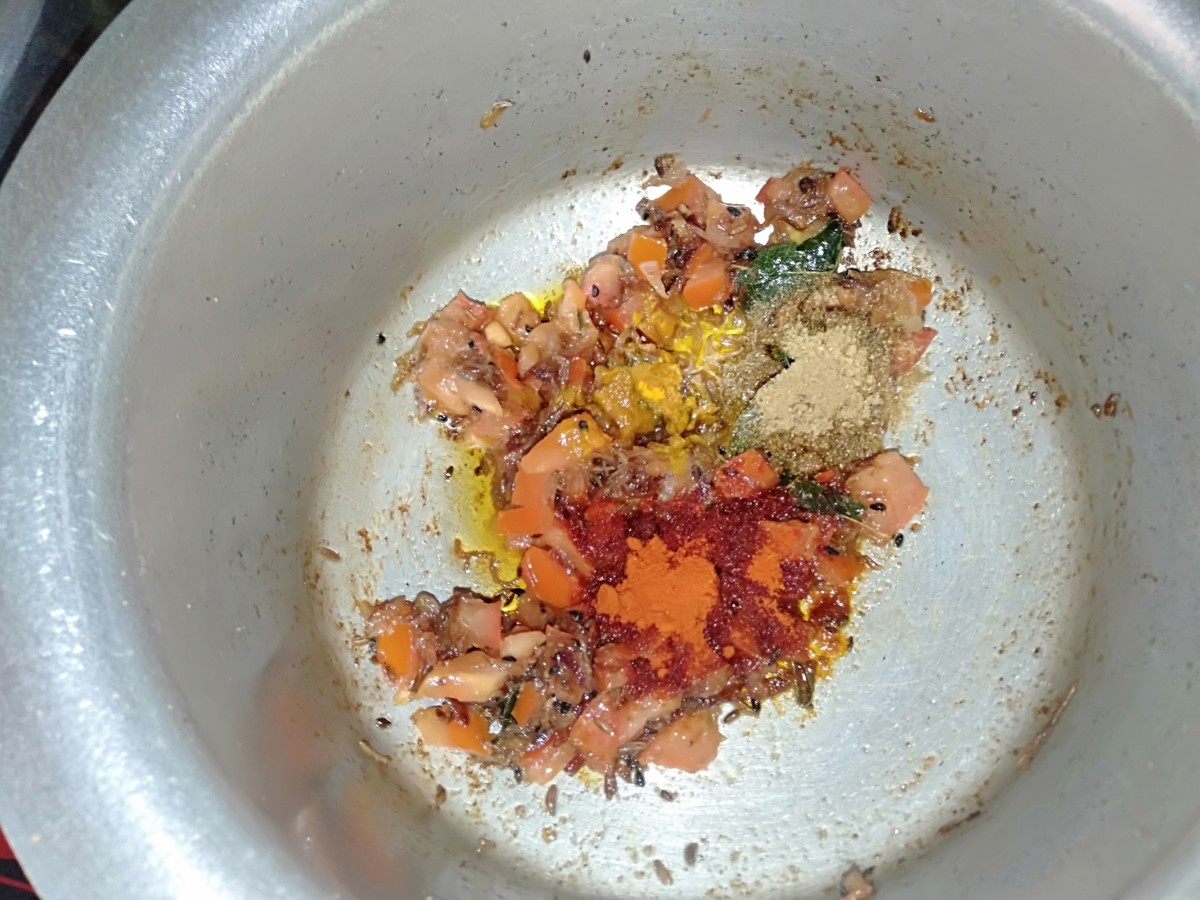 Add chopped tomato, coriander powder, red chilli powder, and turmeric powder. Mix well.