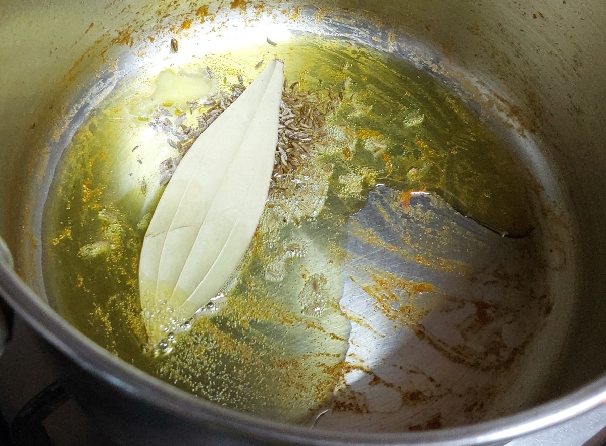 In a pan heat 1-2 tablespoon of oil, add 1-2 bay leaves and 1 teaspoon of cumin seeds. Let the cumin seeds splutter.
