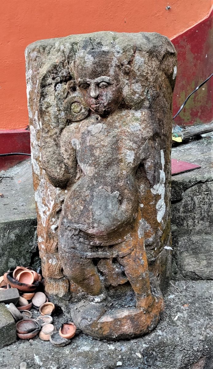 An ancient stone statue outside the temple; Dirgheshwari