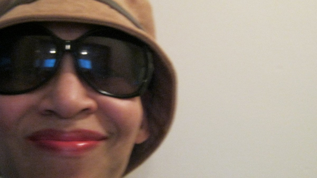 Victoria Moore wearing a brown cloche hat and oversized shades.