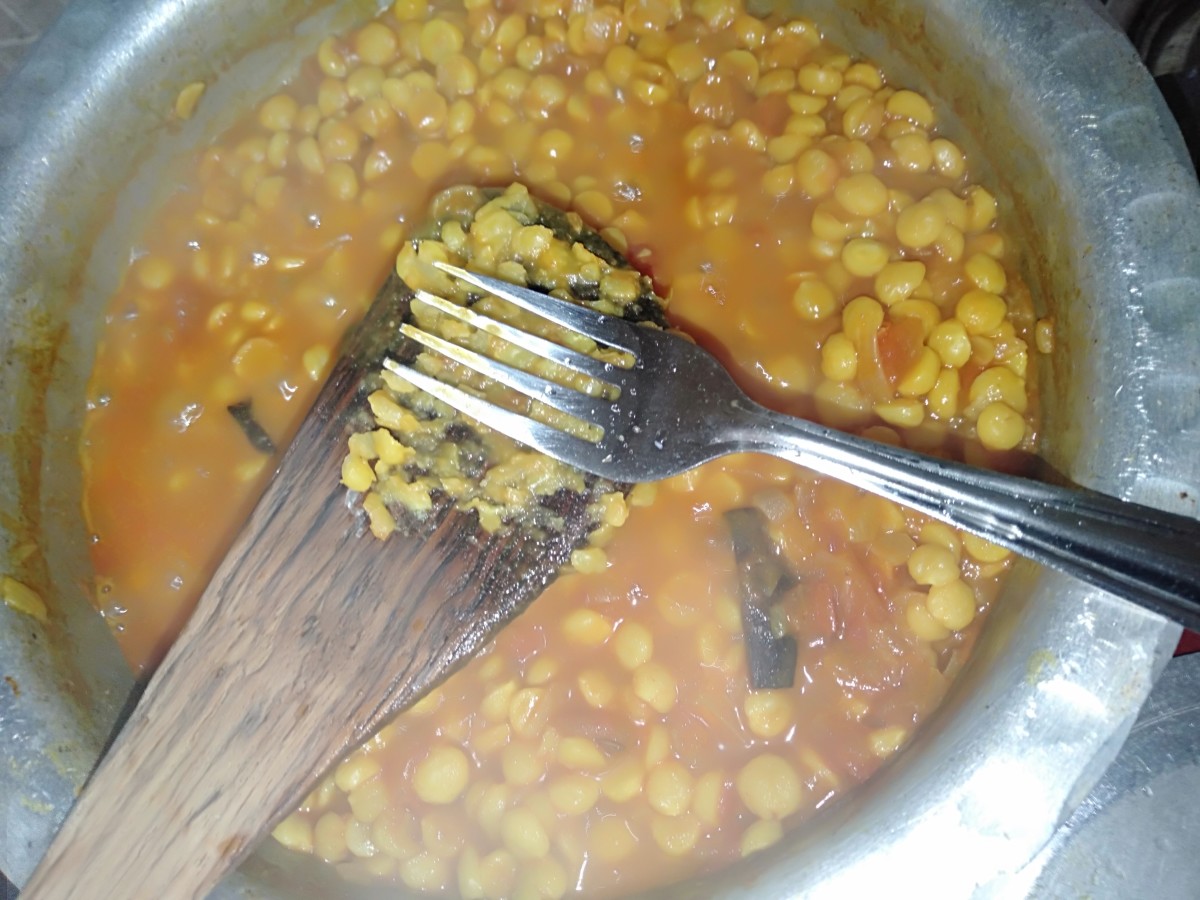 Once the lentils are cooked, take some lentils on a spatula and smash them with the help of fork to form a gravy.