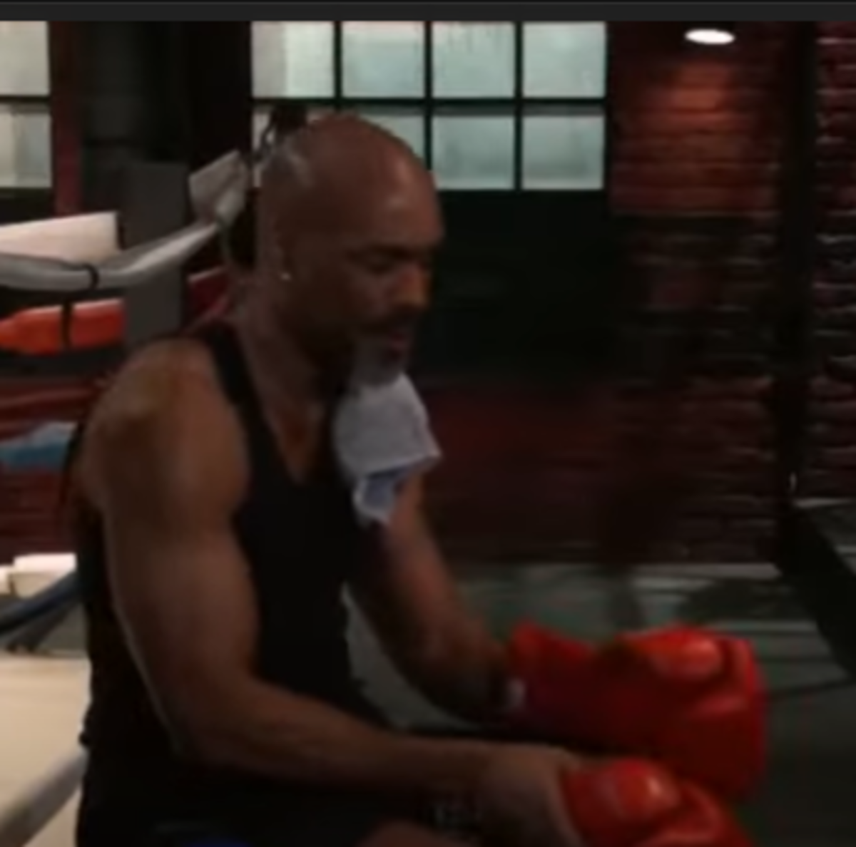 Curtis in black shirt, red boxing gloves and white towel.