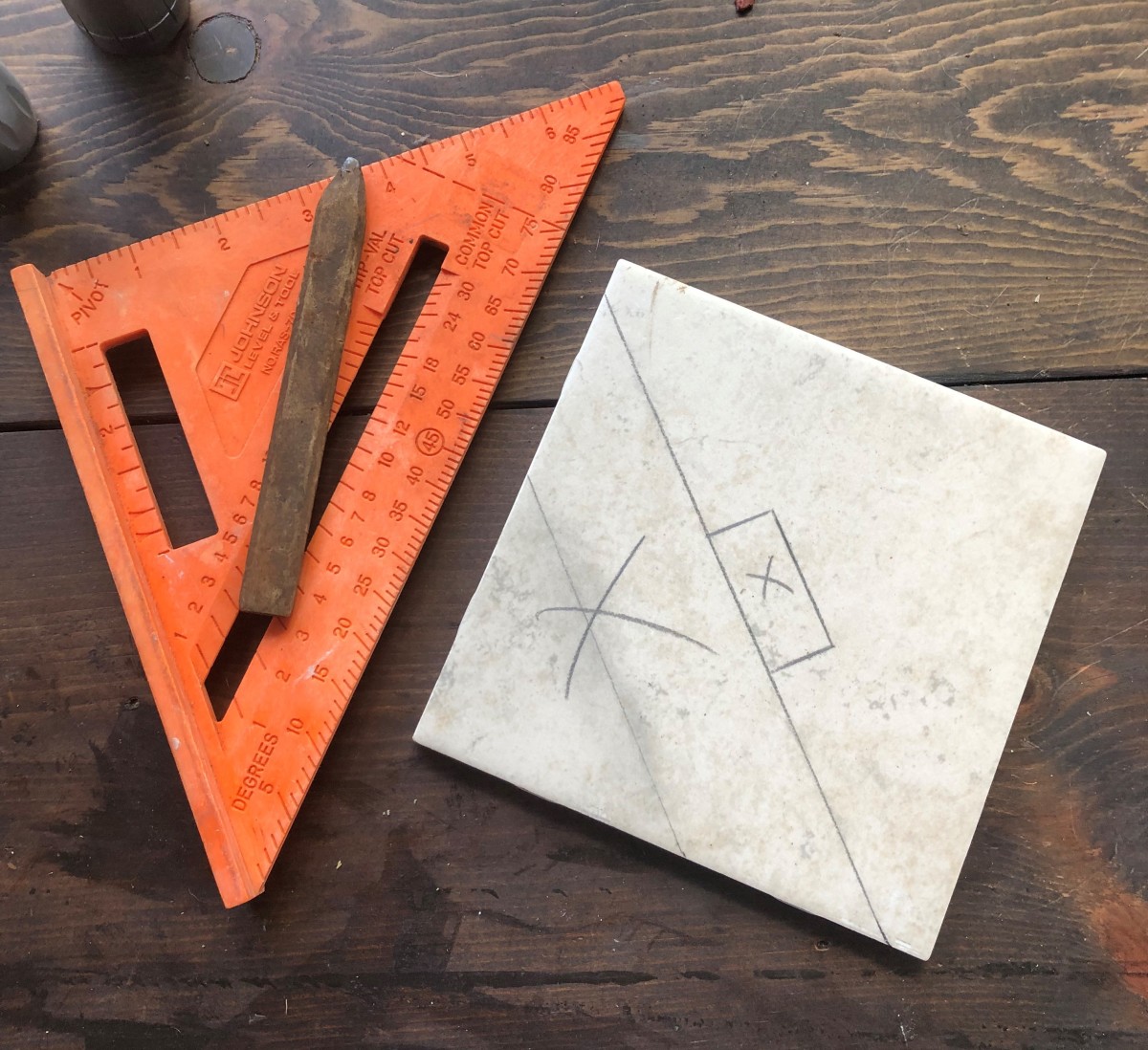 Use a speed square and pencil to layout the cut. Notice the X marks on the unwanted pieces. This comes in handy when making multiple cuts.