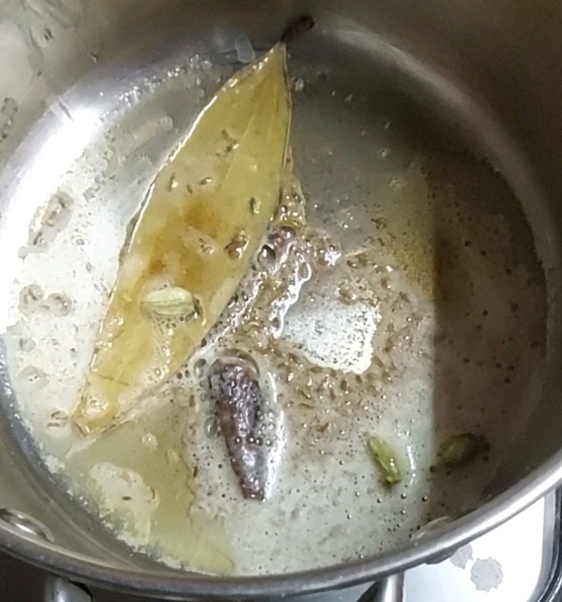 In a pan, heat 2 tablespoons butter and 1 tablespoon ghee or clarified butter. Splutter 1 teaspoon cumin seeds. Add 1–2 bay leaves, 1-inch-long cinnamon stick, 1–2 cloves and 1–2 cardamom pods. Fry for 1 minute.