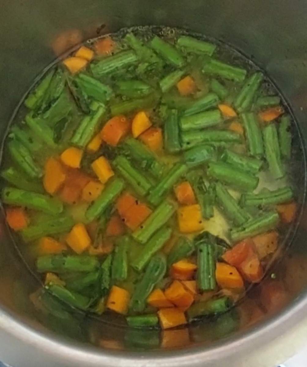 Add chopped carrots and beans and saute for 2 minutes. Add 1/2 teaspoon of turmeric powder, and mix. Add 1/2 cup of water and 1/4 teaspoon of salt.