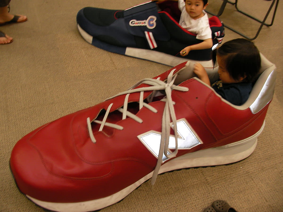 Children play in giant shoes in Japan. This picture plays with scale.