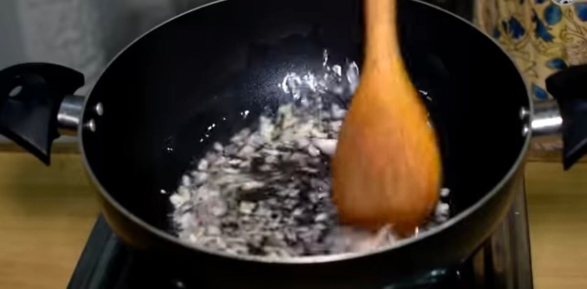 In a pan, fry the chopped onion and garlic paste.