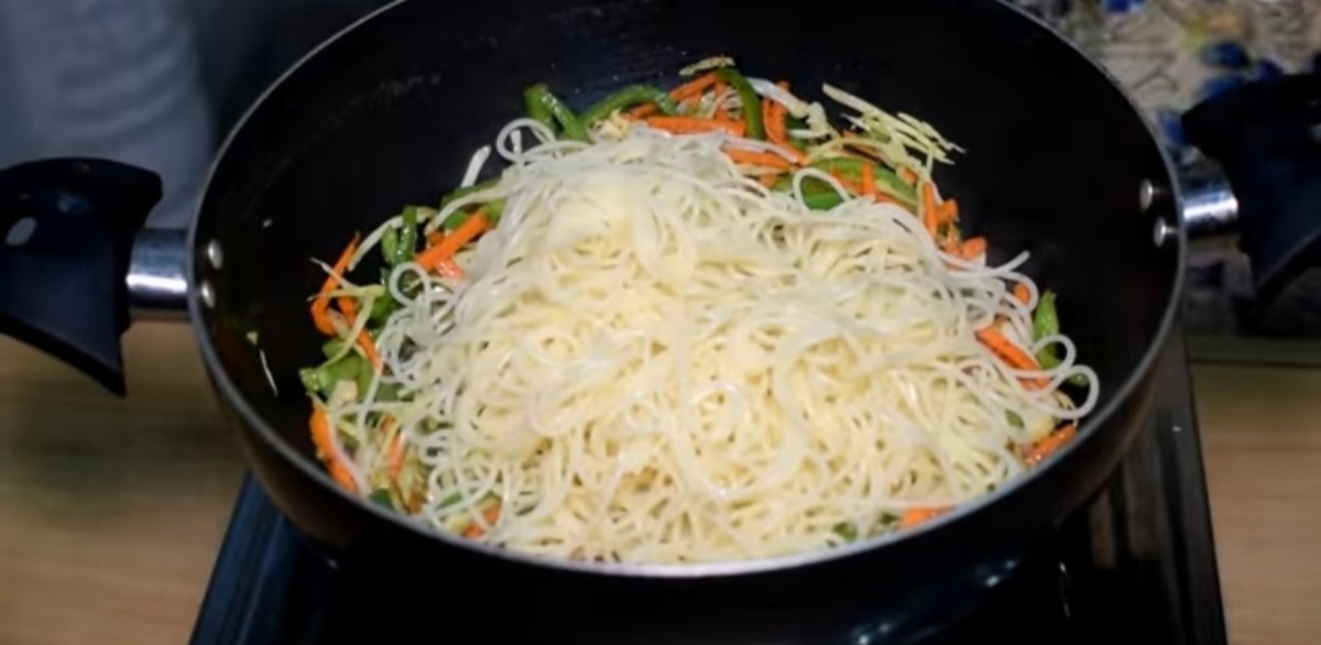 Add the boiled spaghetti to the stir-fried vegetables