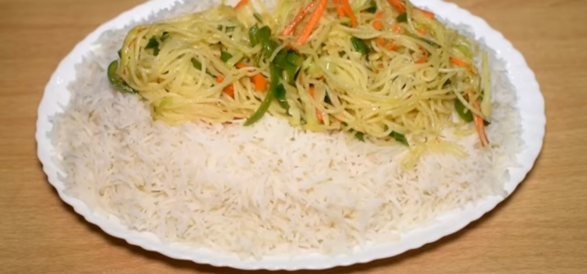 Over the boiled rice, make a layer of spaghetti with stir-fried vegetables.