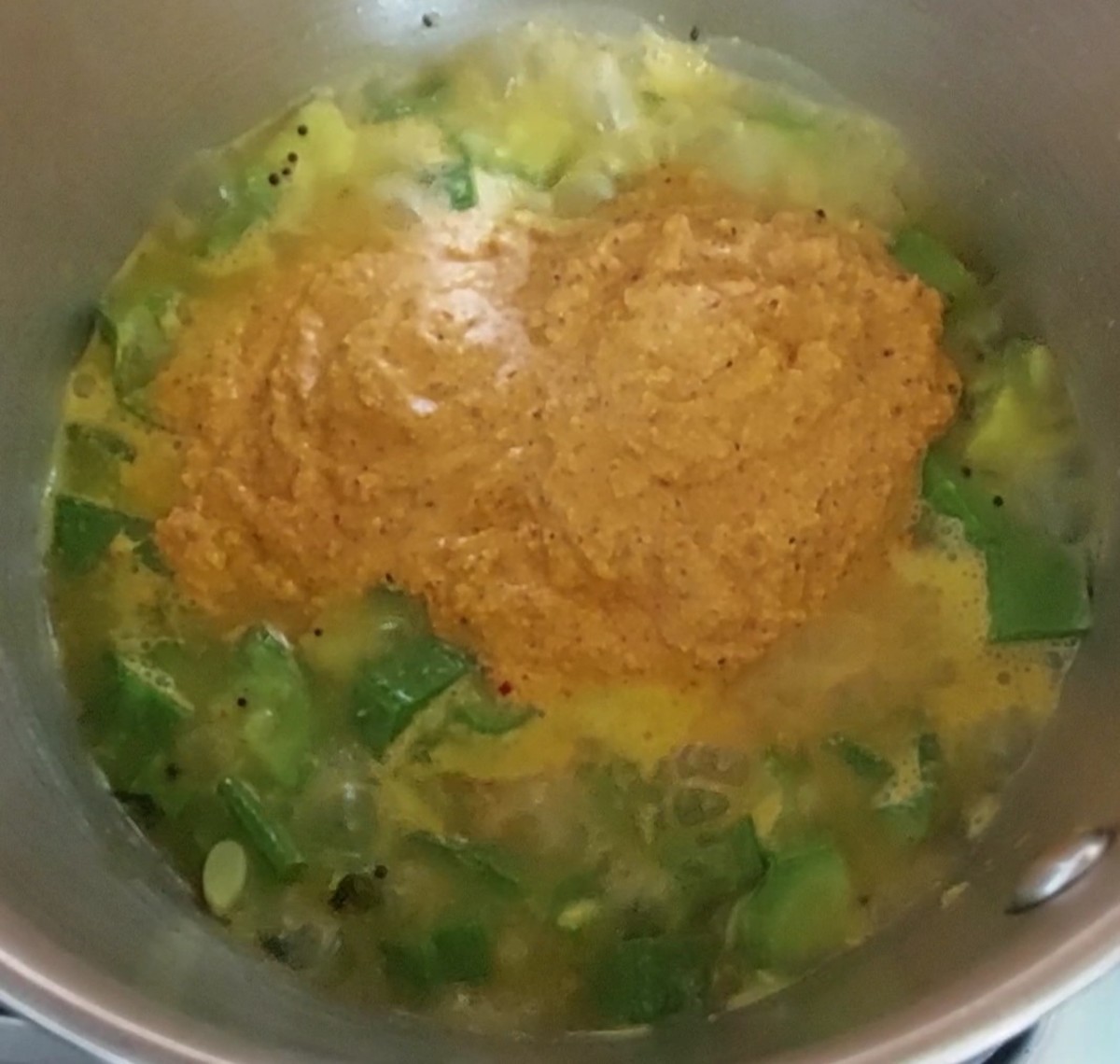 Add the ground paste to the well-cooked vegetable mixture.