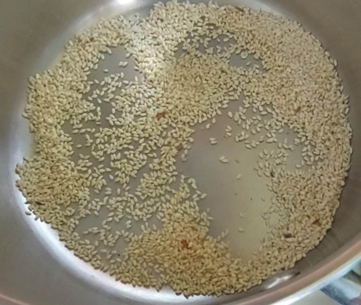 In the same pan, add 2 tablespoons of sesame seeds and fry till the seeds start to splutter and slightly change color. Transfer to a plate.