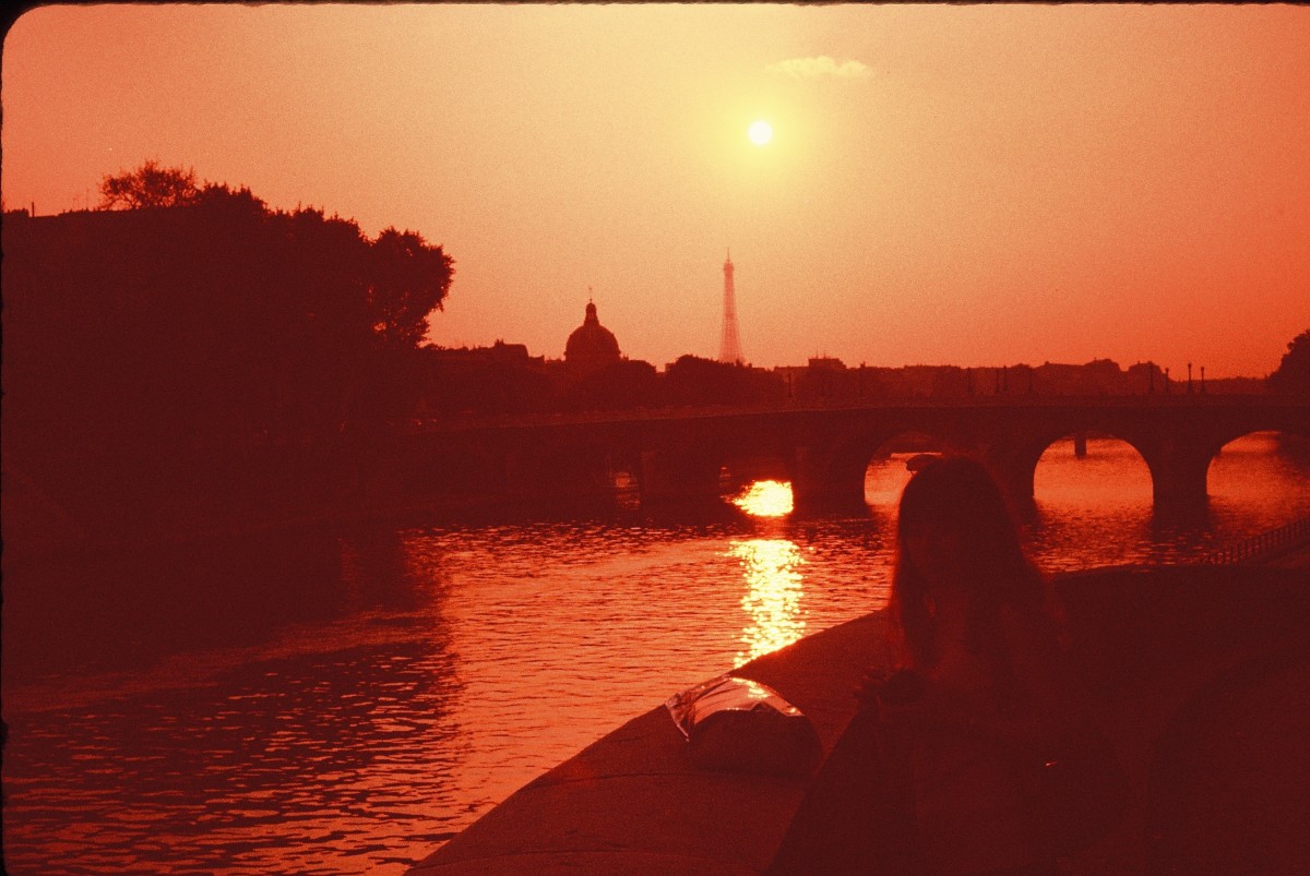 View from Notre Dame Cathedral of the sun setting over Paris's Seine River which flows past the Cathedral
