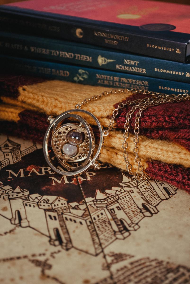Stack of books related to Harry Potter and a timeturner. 
