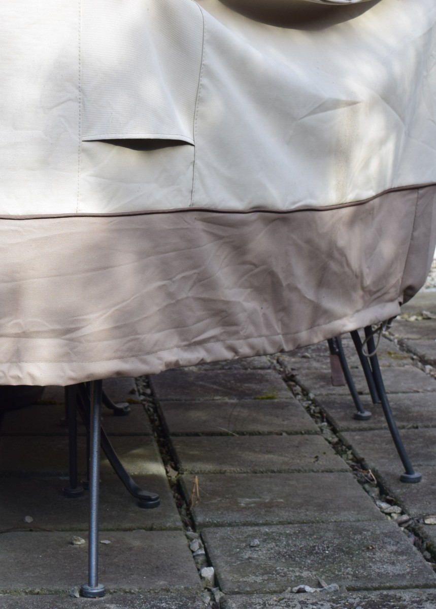 Outdoor table and chairs with cover to protect from winter weather. Maybe the exposed feet need boots.