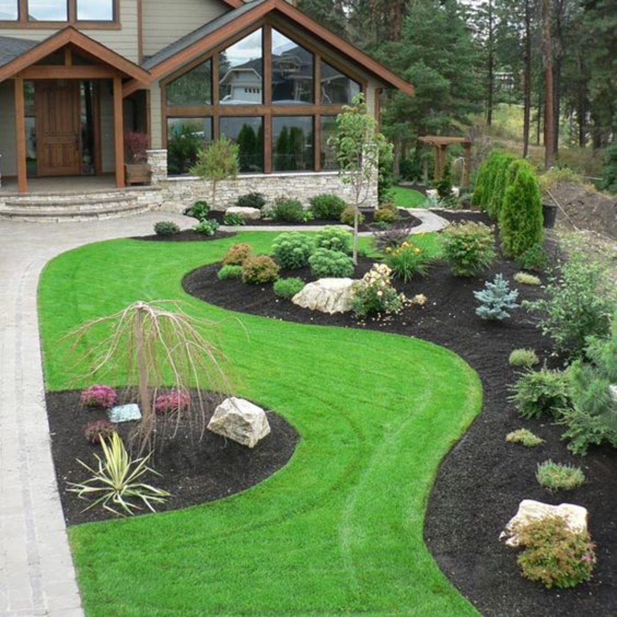 The modern front yard look embraces earth colors and creative use of stones.