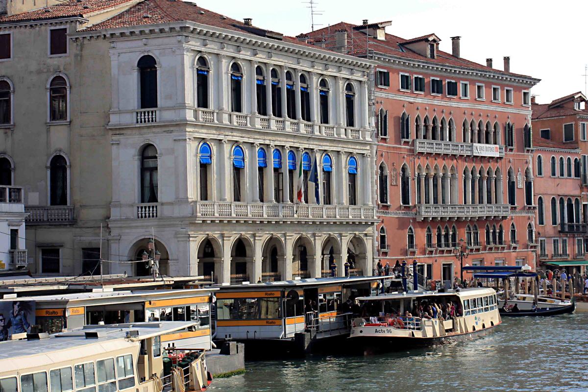 The 16th century Palacco Dolfin Manin (the white building), is now home to the Bank of Italy. The 15th century Palazzo Bembo (the terracotta pink building), today houses art exhibitions. In the foreground of this image is the Rialto water bus stop
