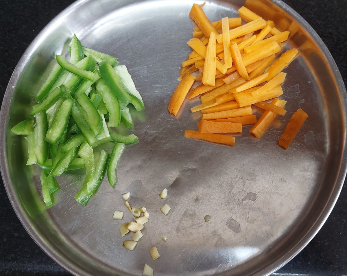Chop carrots, capsicum, garlic cloves and green chilies. Set aside.
