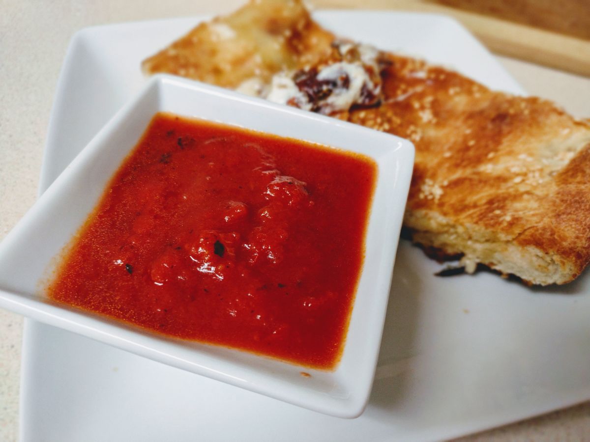 Sausage, spinach, and mushroom calzone with a side of marinara 
