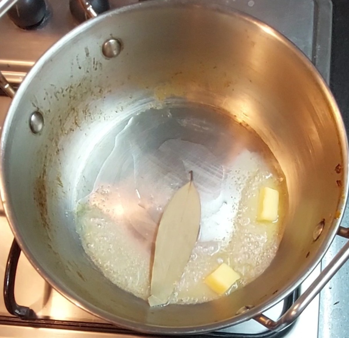 In a pan, heat 2 tablespoons of butter and 1 tablespoon oil or ghee. Add 1-2 bay leaves and saute.