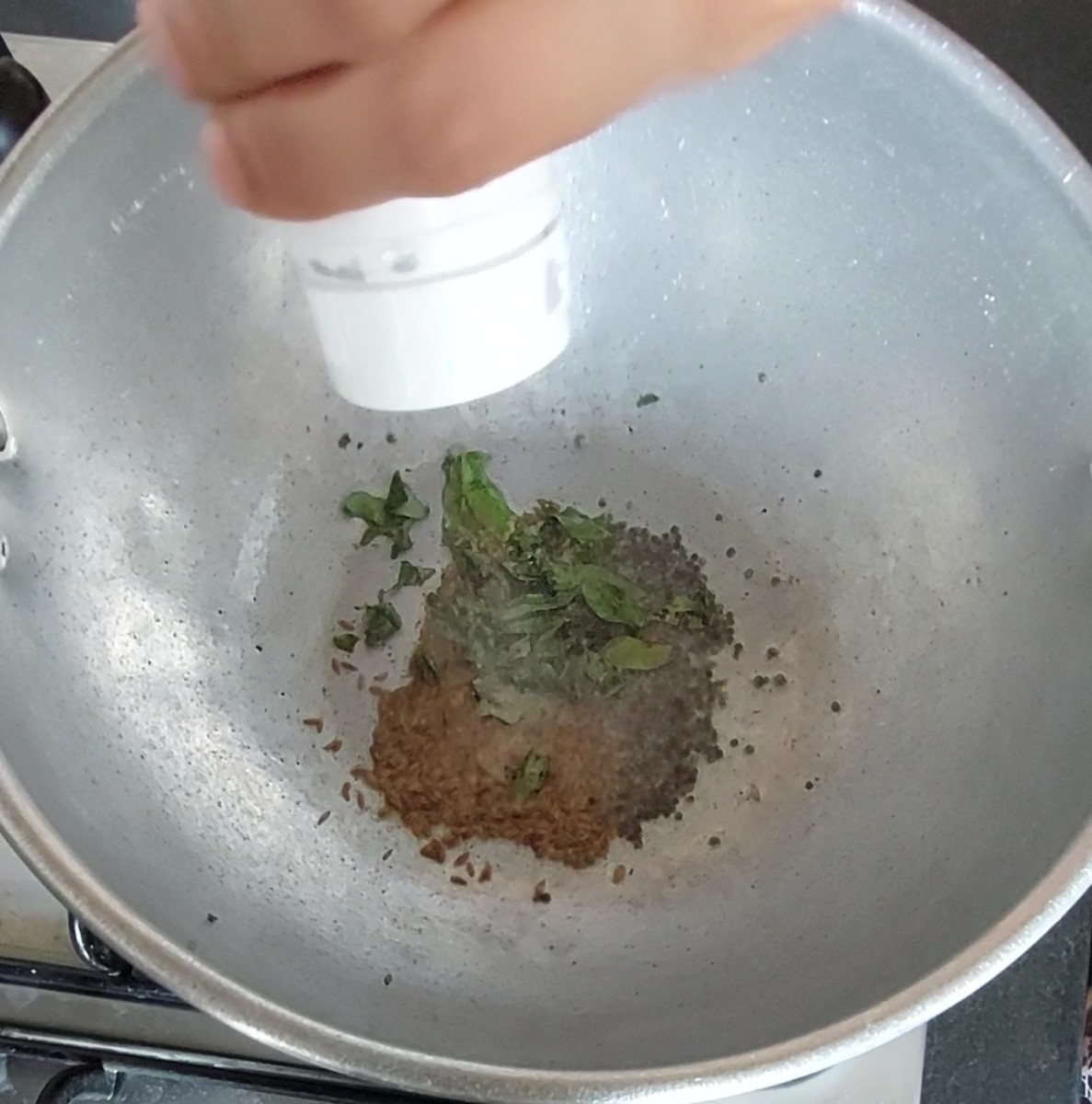 In a pan, heat 2 tablespoons of oil. Splutter 1/2 teaspoon mustard seeds and 1 teaspoon cumin seeds. Add 1-2 sprigs of curry leaves and 1/4 teaspoon hing (asafoetida).