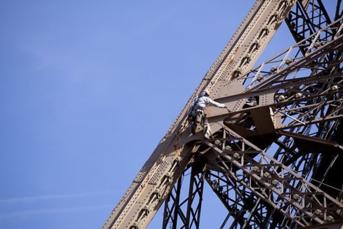 Eiffel Tower maintenance workers sensibly wear safety harnesses.