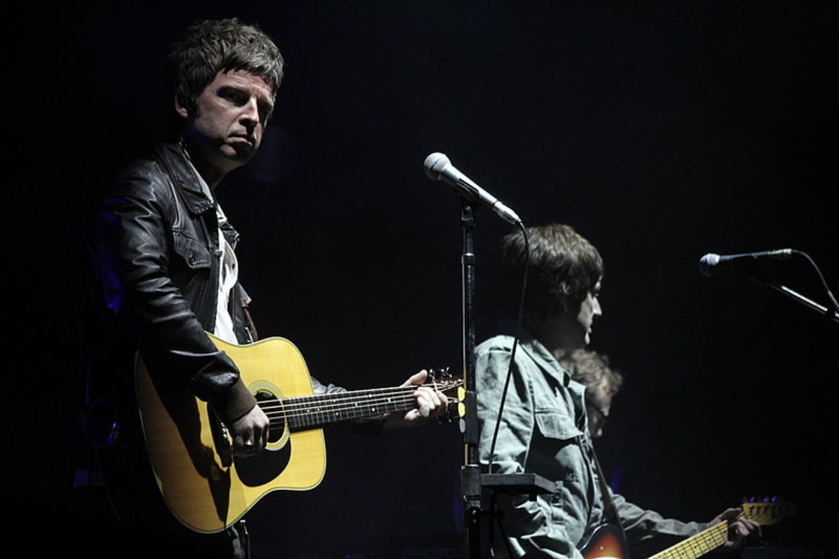 Noel Gallagher, who composed, wrote, and sang 'The Importance of Being Idle' plays the acoustic guitar in one of his countless live performances.