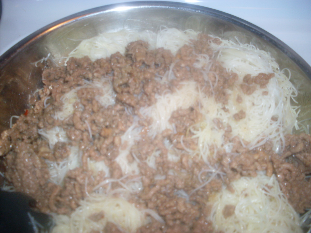 Stirring & mixing delicious ground beef and rice noodles together.
