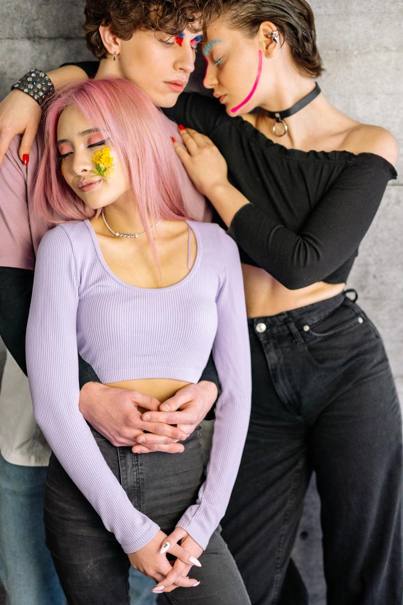 There is a lot going on here that screams Libra. The midriff cut shirts, the pink eyeshadow, the lavender shade of the sweater, the pinkish shirt the man is wearing, the fun hairstyles, and the wild makeup.