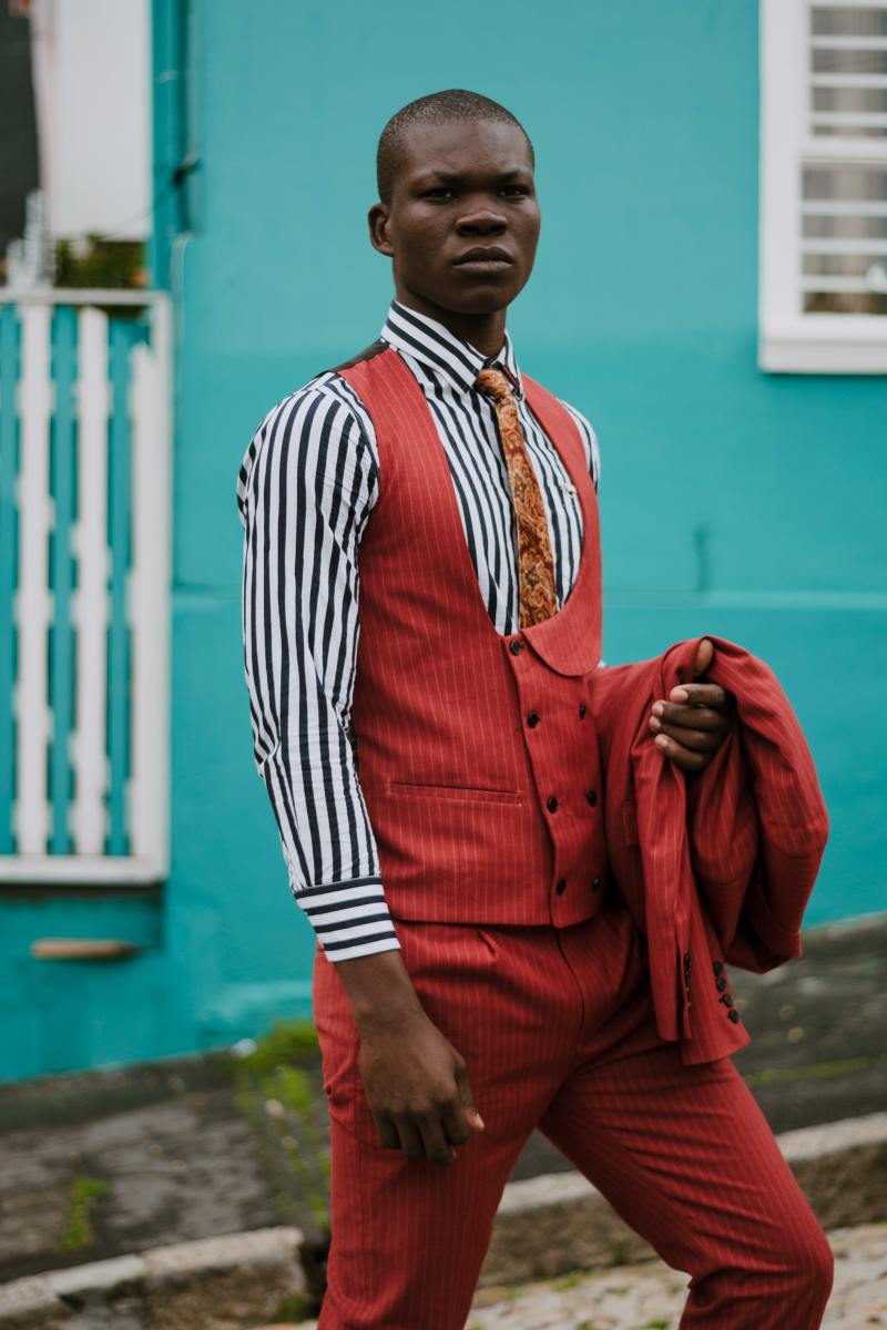 A red suit with stripes conveys power and decisiveness. The shirt with stripes adds a contrast that will command attention.