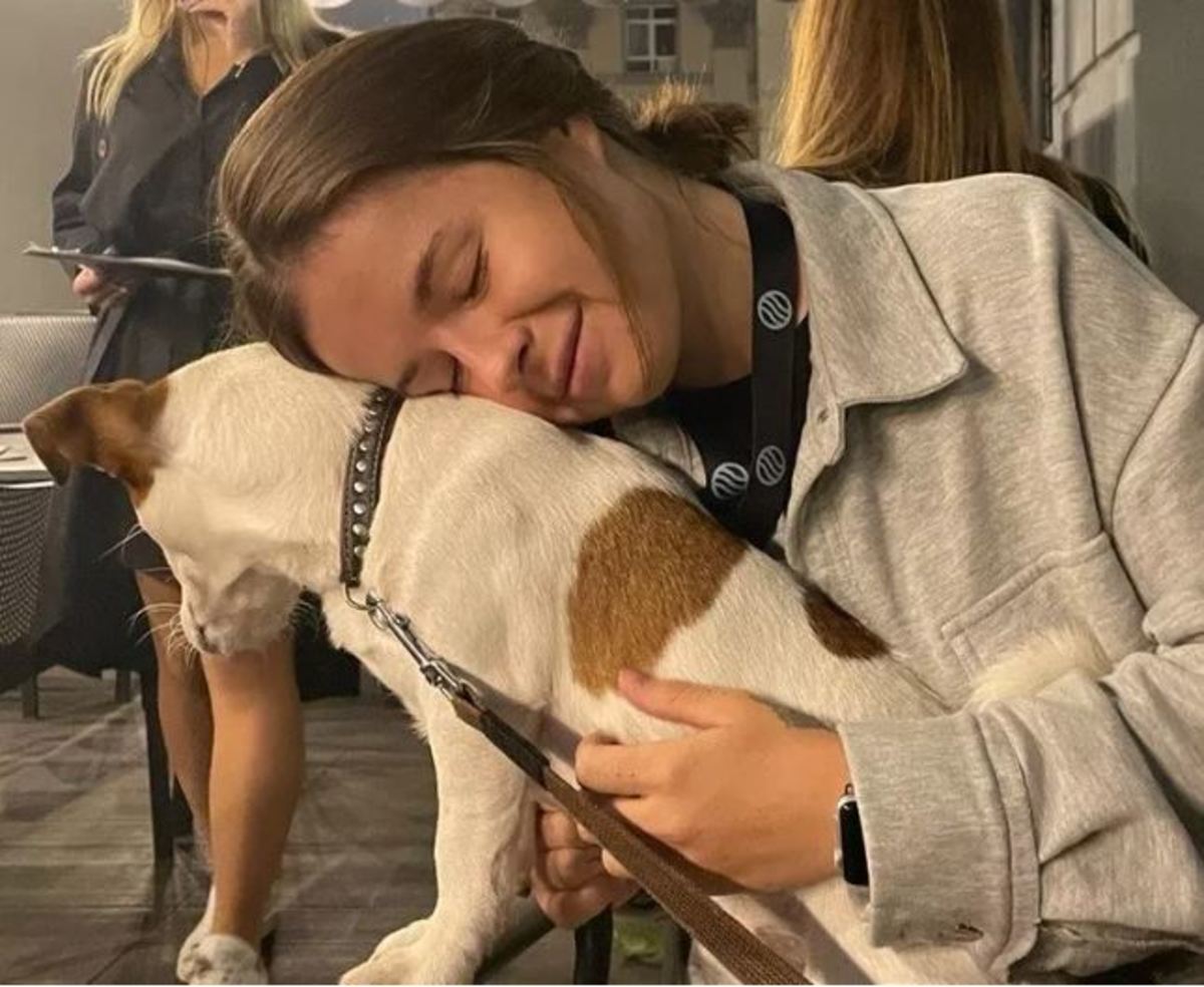 Anastasiya hugging a dog at a pet shelter.