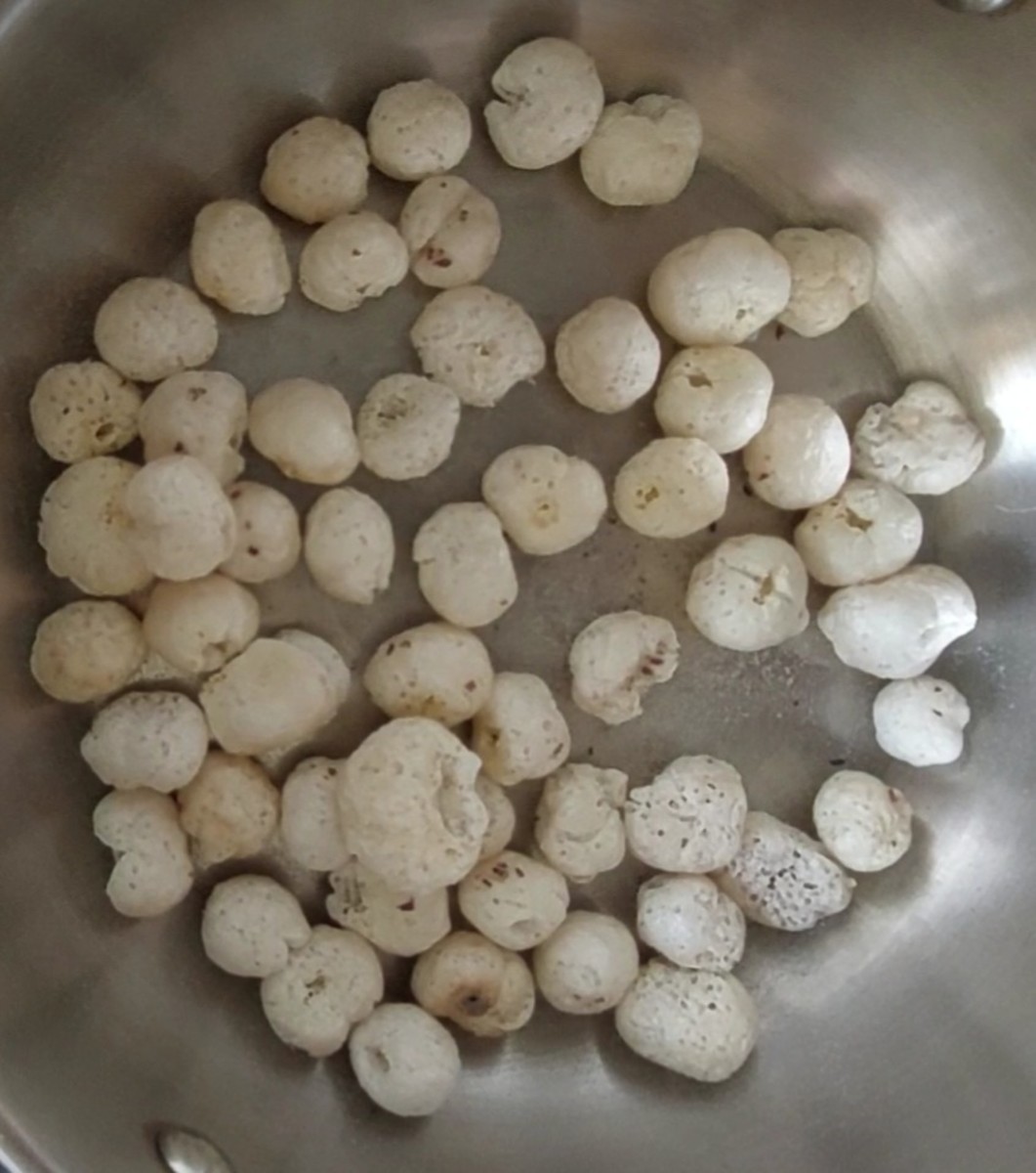 In a pan add 1 cup of lotus seeds (makhana) and fry over low flame till they are almost crisp (do not burn). Transfer to a plate.