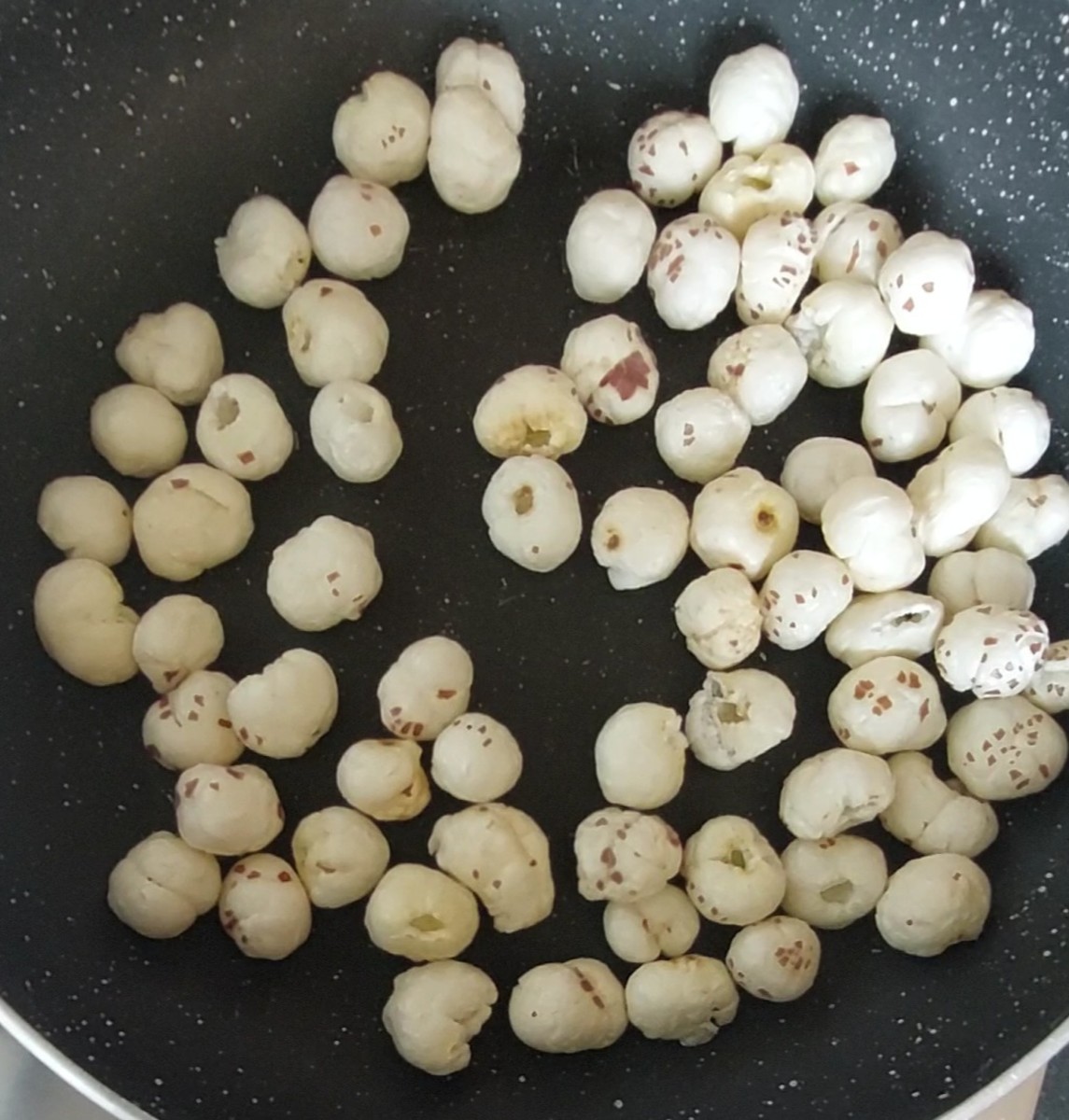 In a pan, add 1 cup of lotus seeds or makhana. Dry-fry over low flame for 2-3 minutes or till crispy (do not burn the seeds). Once done switch off the flame.