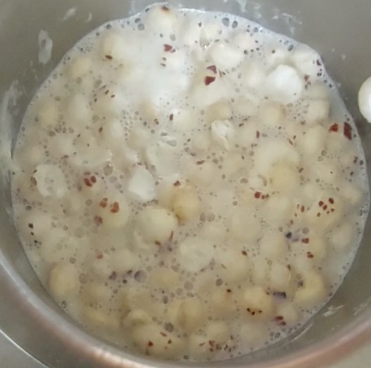 After the milk thickens, add chopped lotus seeds and mix well. Bring it back to a boil.