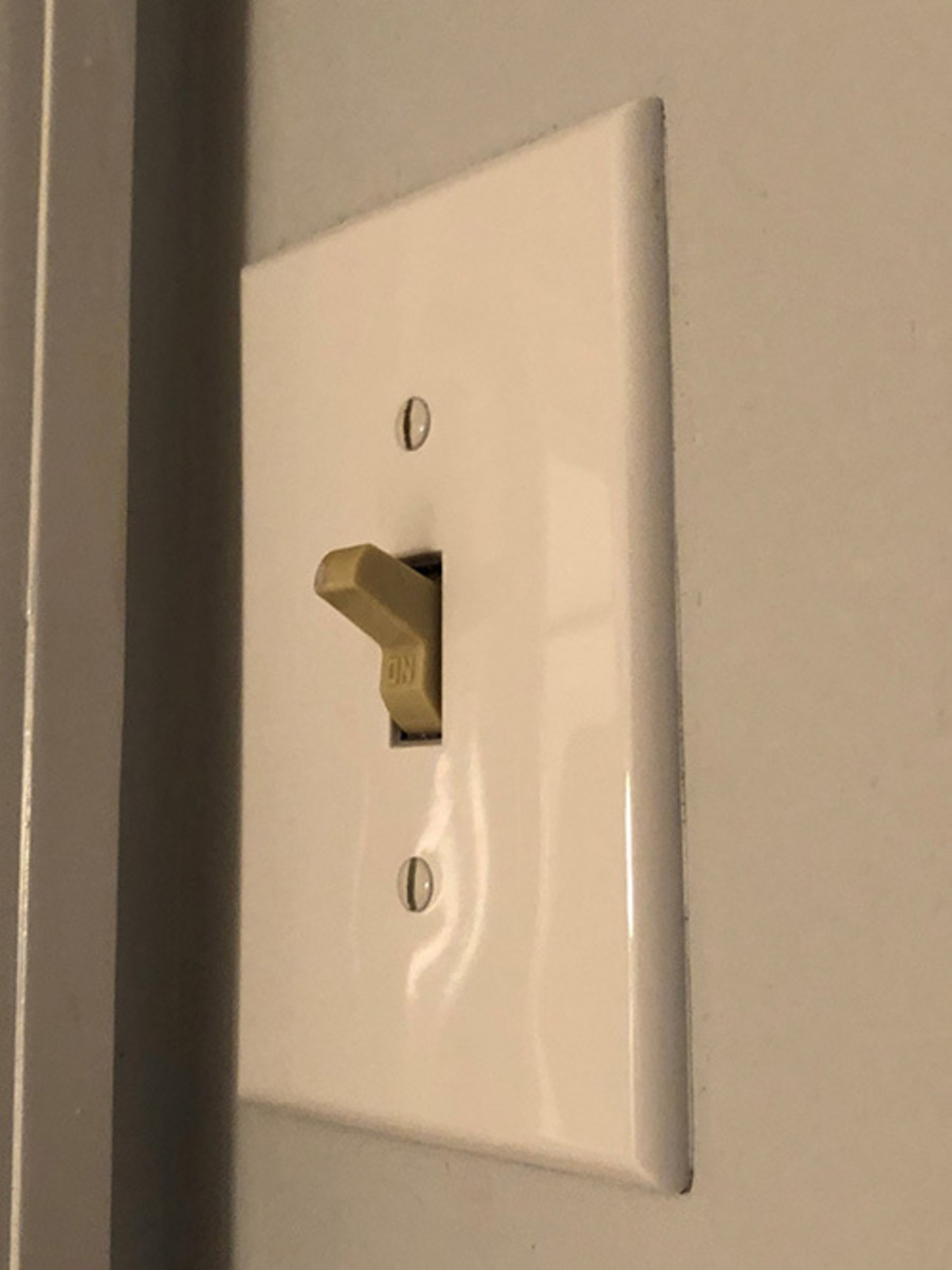 the light switch on the wall, near the ceiling