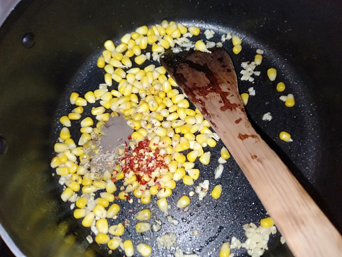 Add boiled corn, ½ tsp chilli flakes, ½ tsp oregano, and ½ tsp black pepper powder.
