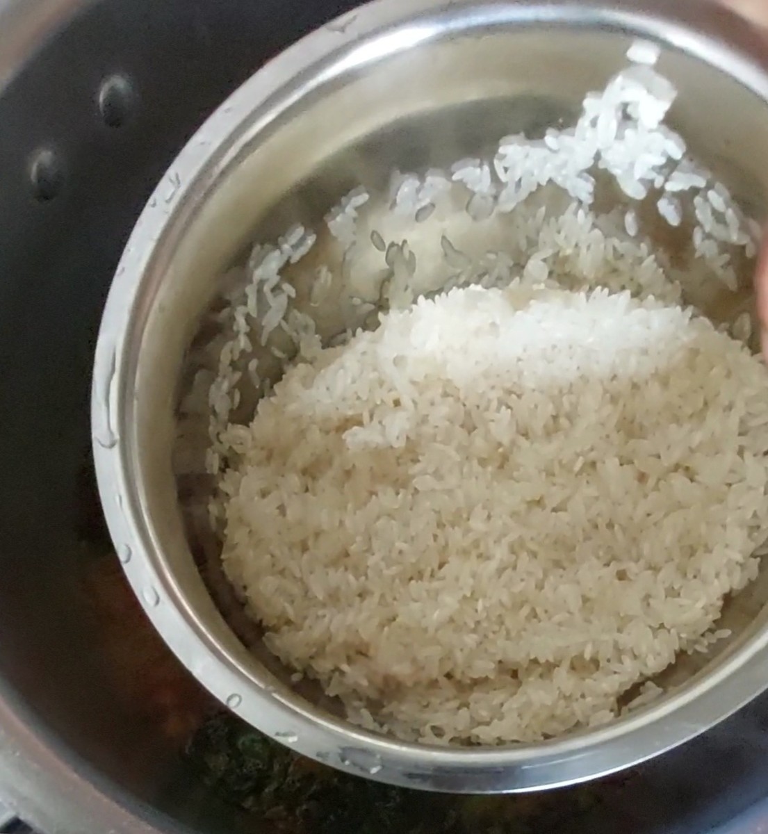 When the water starts boiling, add 1 cup of rinsed rice, mix well, close the lid of the cooker and take 3 whistles. Switch off the flame and let the pressure settle down.