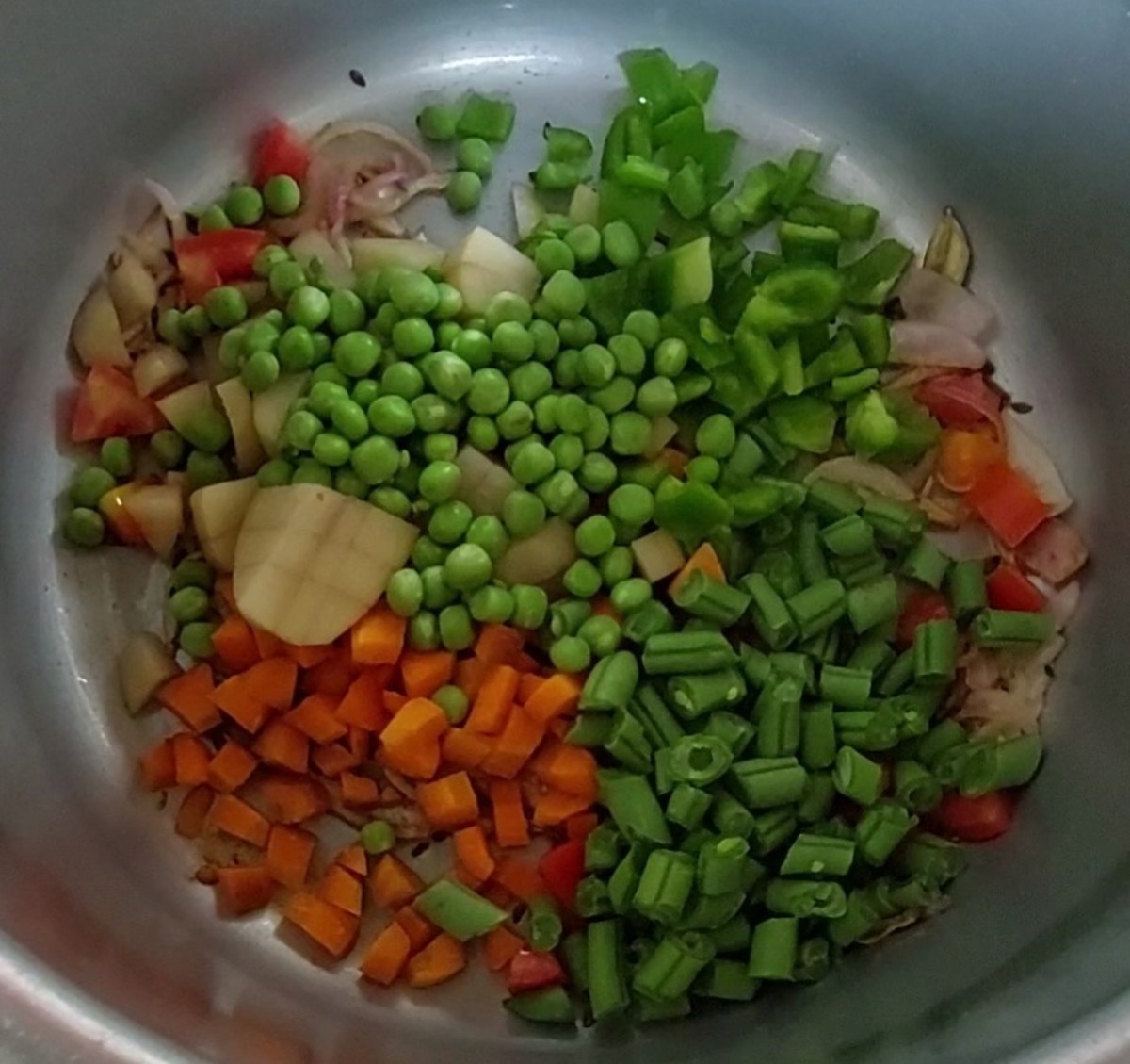 Add 1 cup carrots,1 cup French beans, 1 cup potatoes, 1/2 cup capsicum and 1 cup peas. Saute for a minute.