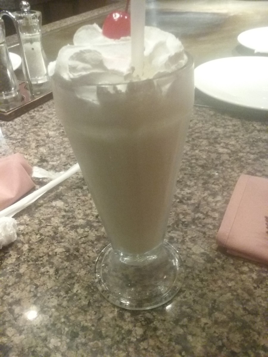 Delicious and creamy non-alcoholic pina colada drink with a generous amount of whipped cream and a marachino cherry on top, served at Arigato Japanese Steak and Seafood House restaurant.