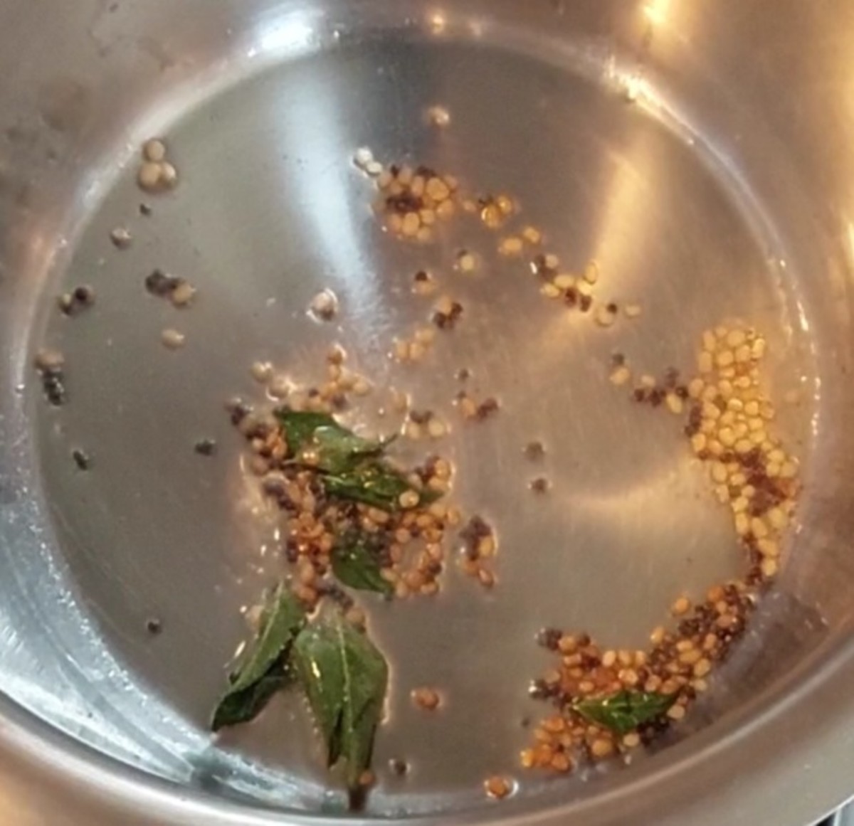 In a pan, heat 1 tablespoon oil and splutter 1/2 teaspoon mustard seeds. Add 1 teaspoon urad dal and fry till it turns golden brown. Add a sprig of curry leaves and 1/4 teaspoon hing. Mix well.