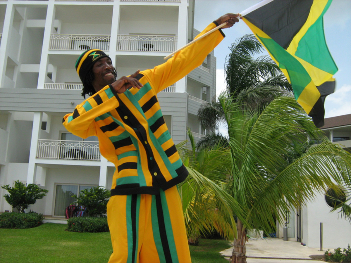 A man holding a Jamaican Celebration Flag and wearing his country's official colors. 