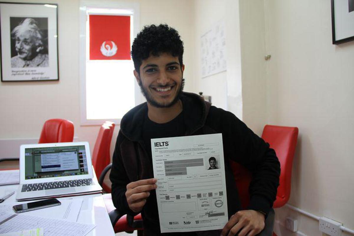 An English language student proudly showing his results on the International English Language Testing System (IELTS).