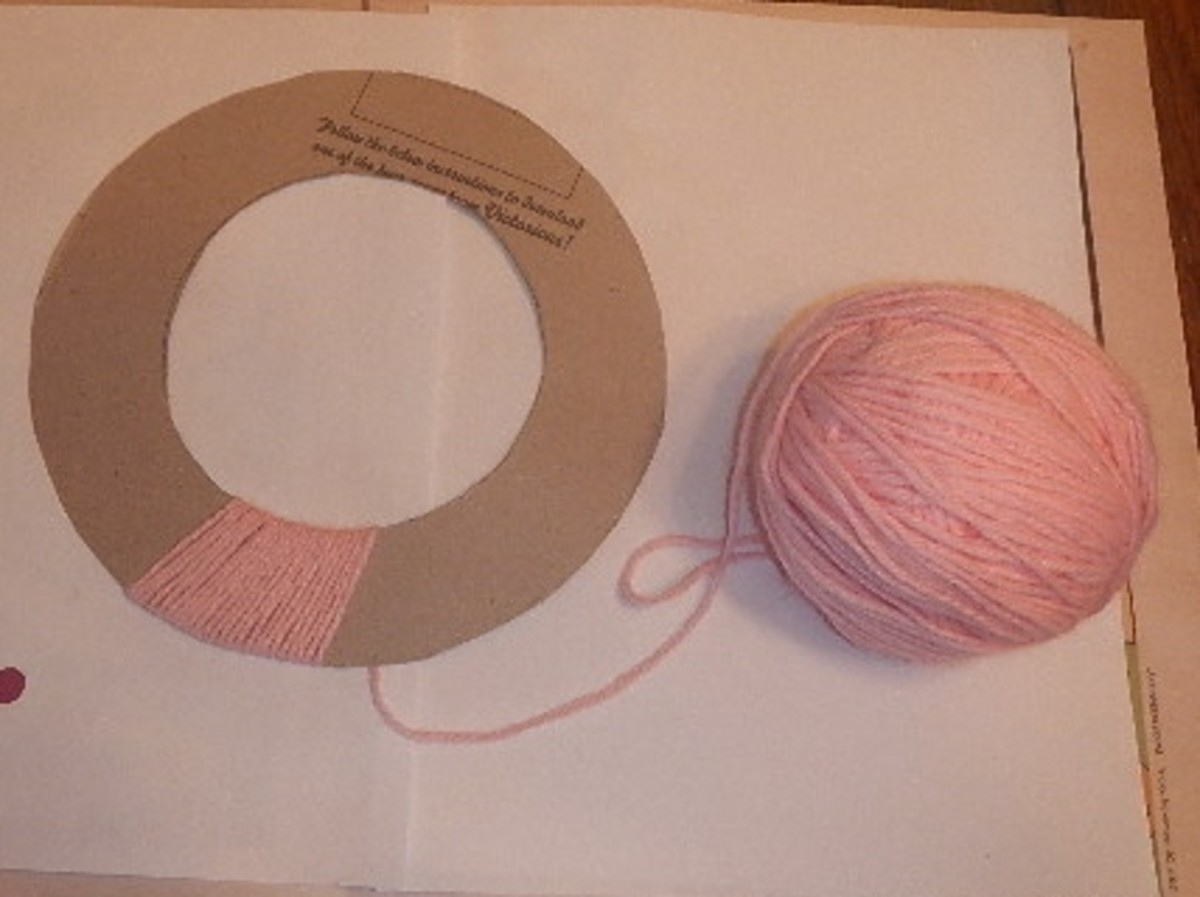 Use hot glue to hold down the end of the yarn and then wrap it around the cardboard, covering it completely. 