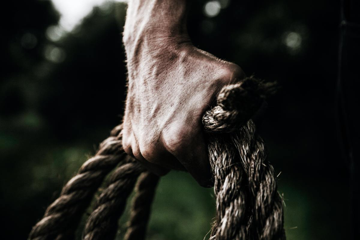 man holding a coiled rope