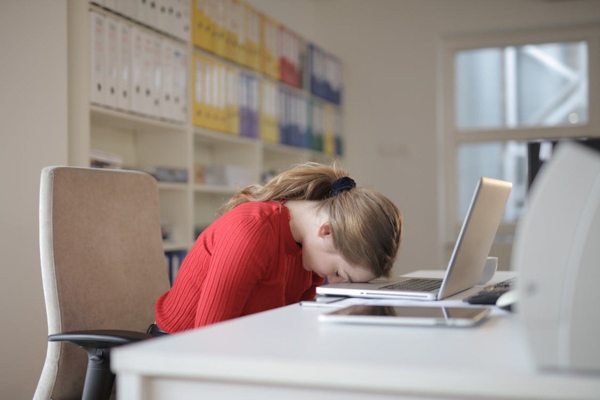 Women exhausted with work leaning on the laptop