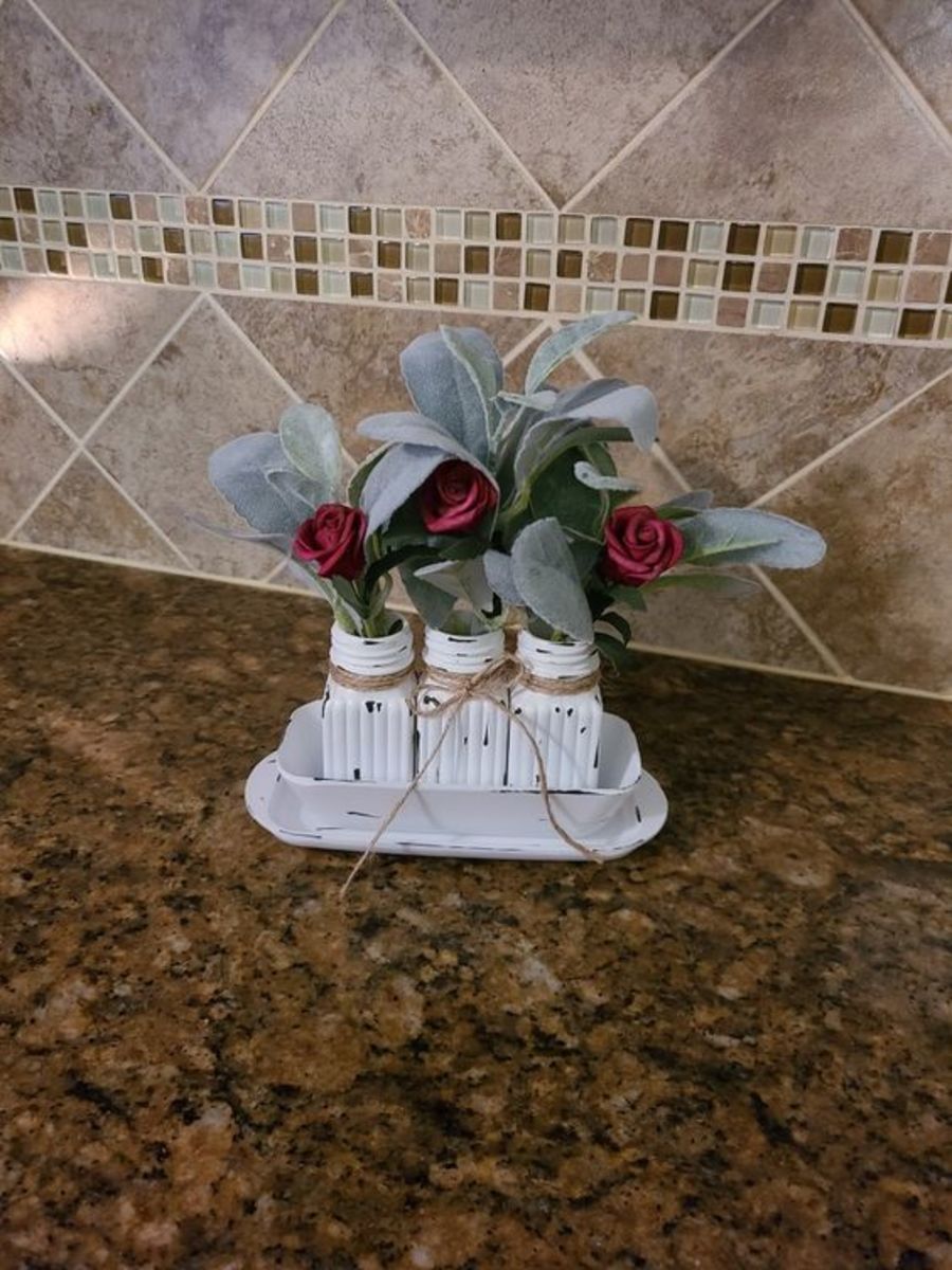 Salt and pepper shakers and butter dish from Dollar tree are easily transformed into a stunning centerpiece with some paint.