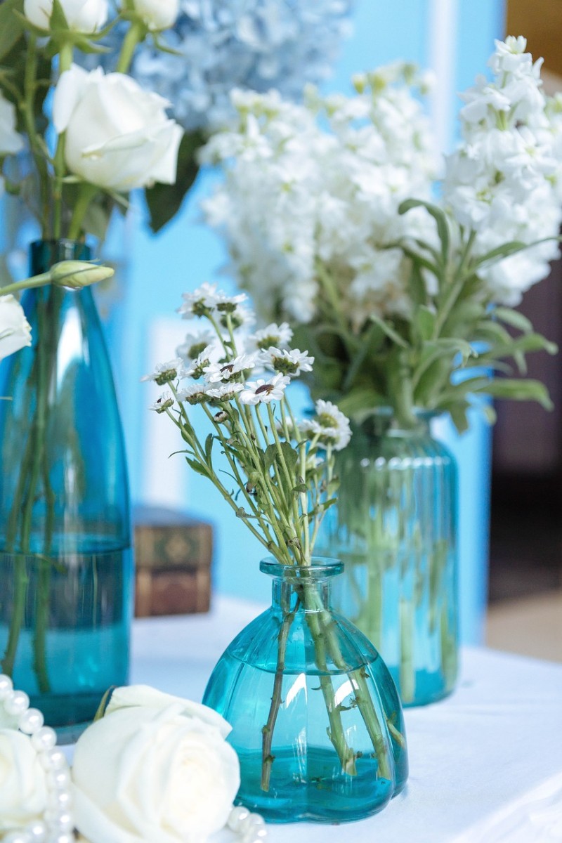 An assortment of thrift store vases in one color decorated the tables.