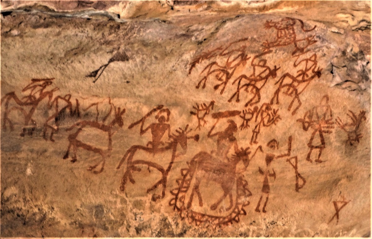 Pre-historic rock painting showing men with spears; some the men are on horseback. Bhimbethka, Madhya Pradesh, India