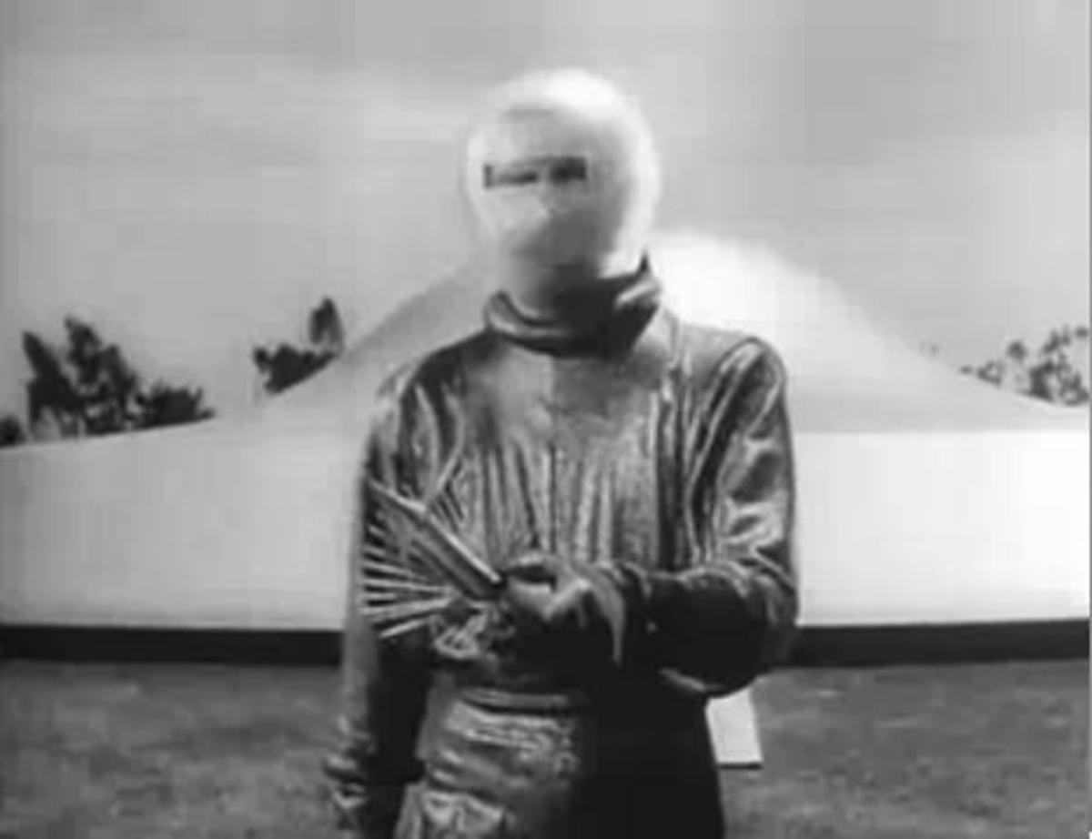A helmet wearing Klaatu holding what could be mistaken for a weapon.
