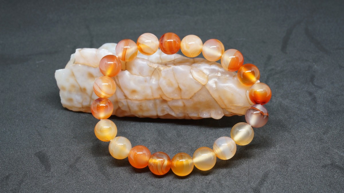 A coral bracelet is displayed on a piece of coral rock.